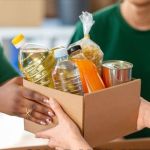 A box of food is handed from one person to another.